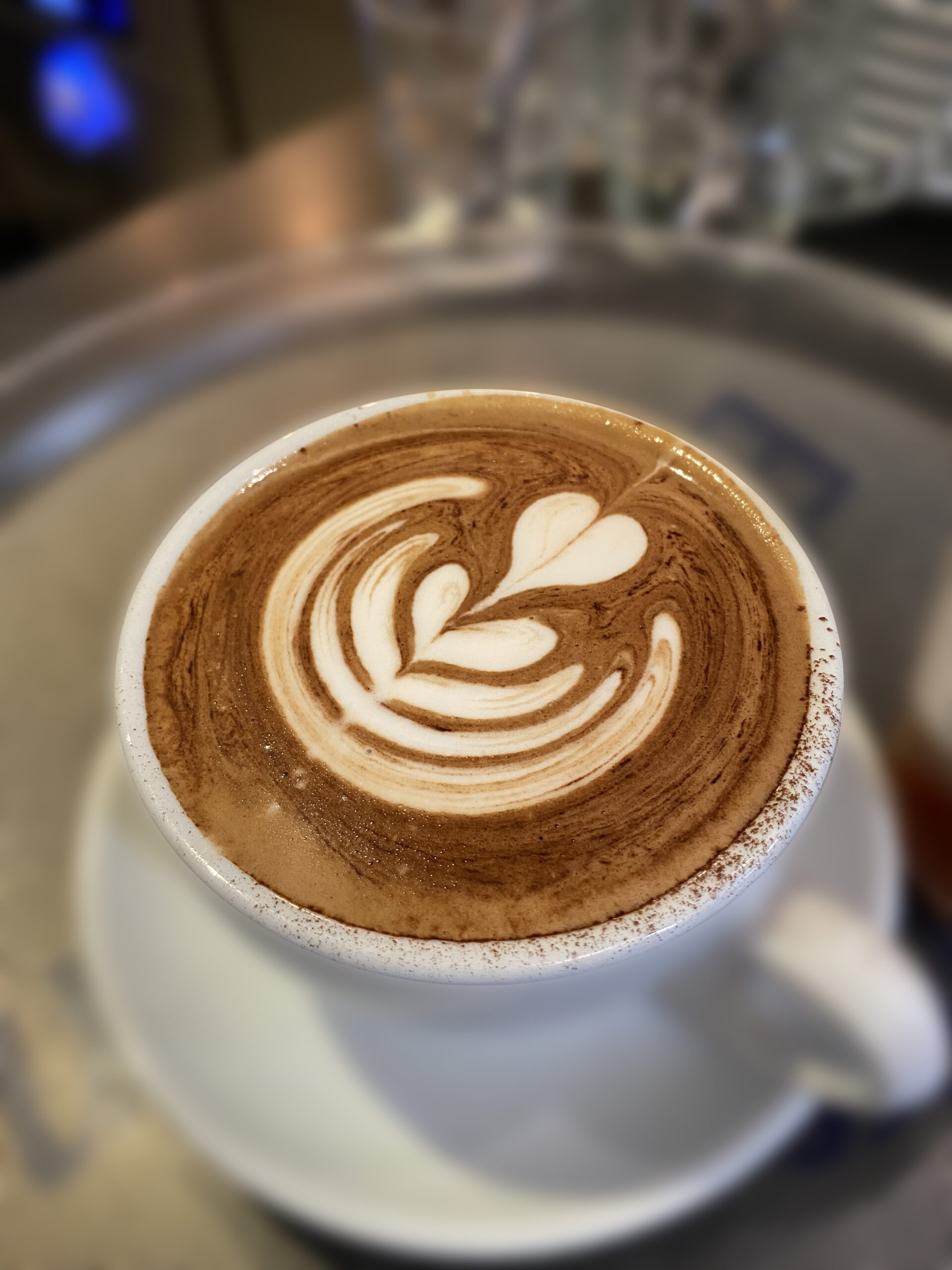 Schöner Cappuccino mit Kakao und besonders schönem Latte Art